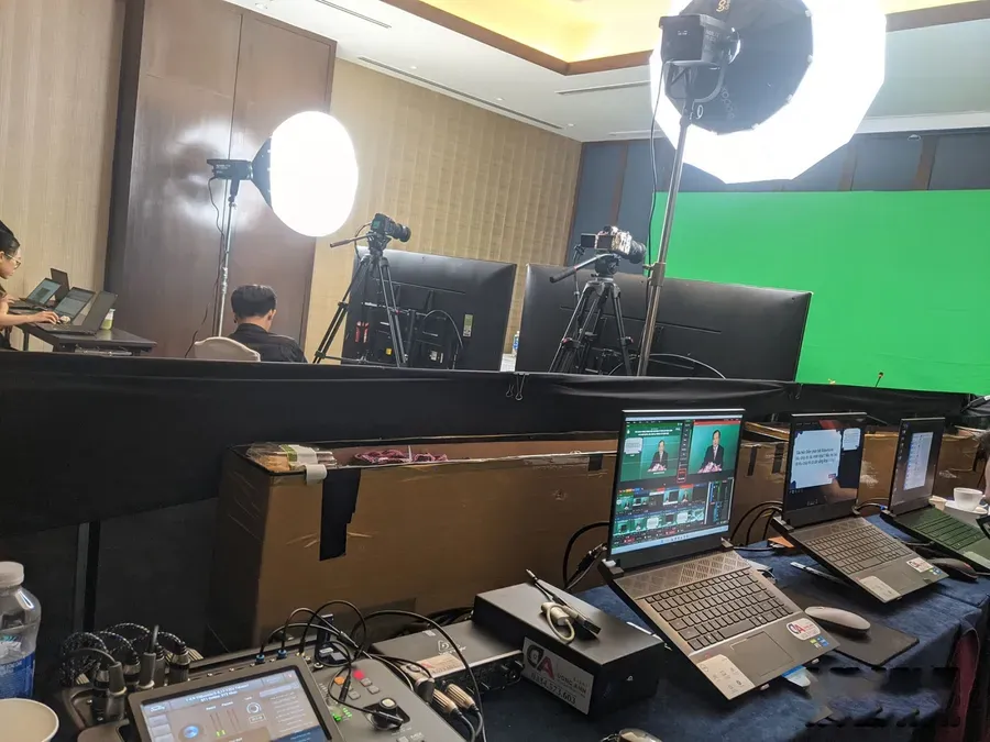 Filming and livestream crew with green screen, cameras and a technical desk