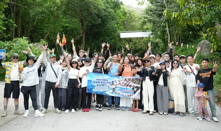 Đội ngũ MIMA giơ tay chào trong chuyến team building giữa rừng cây